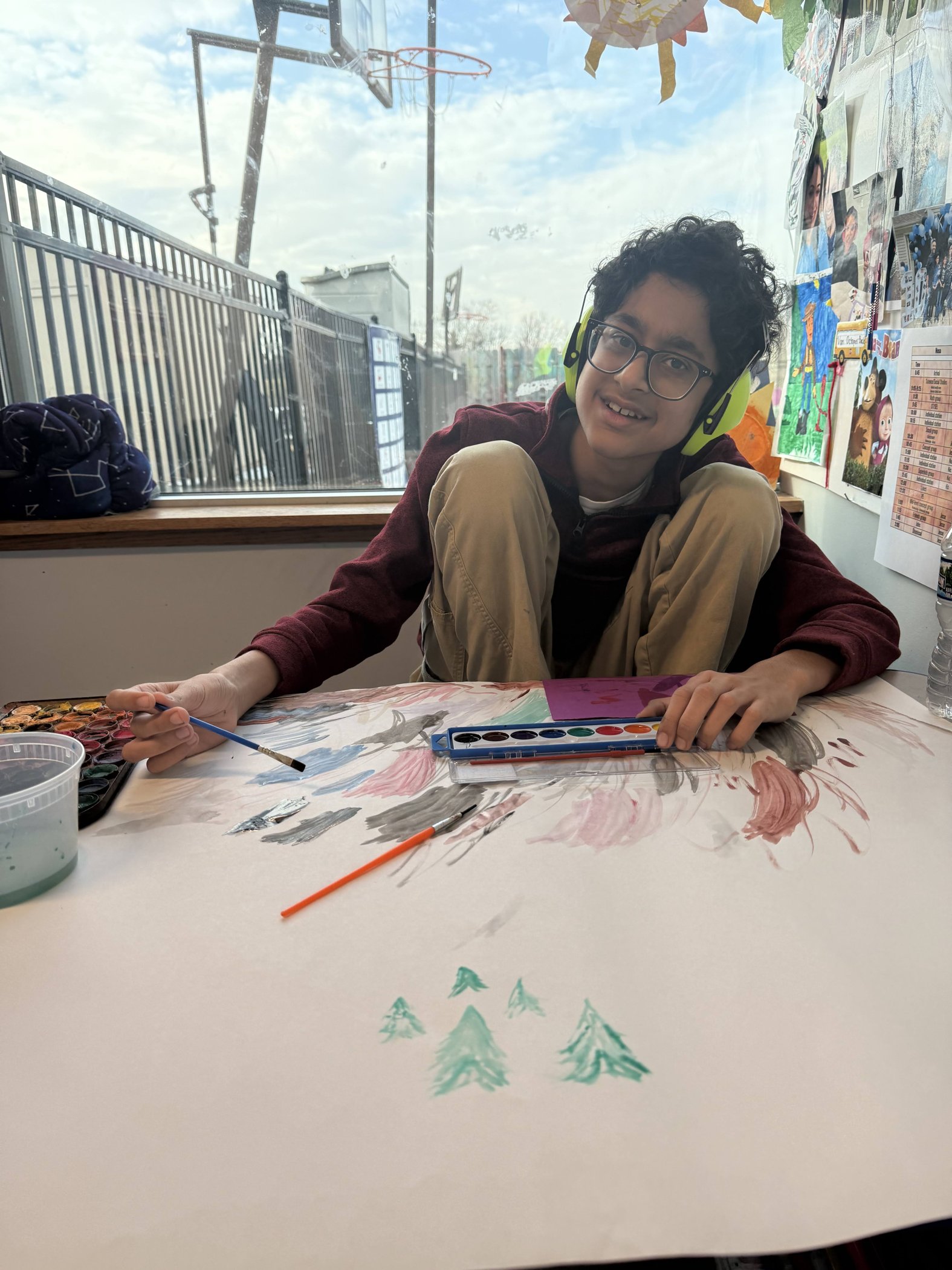 Student painting with noise-reducing headphones